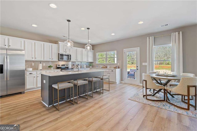 kitchen featuring white cabinets, appliances with stainless steel finishes, visible vents, and light countertops