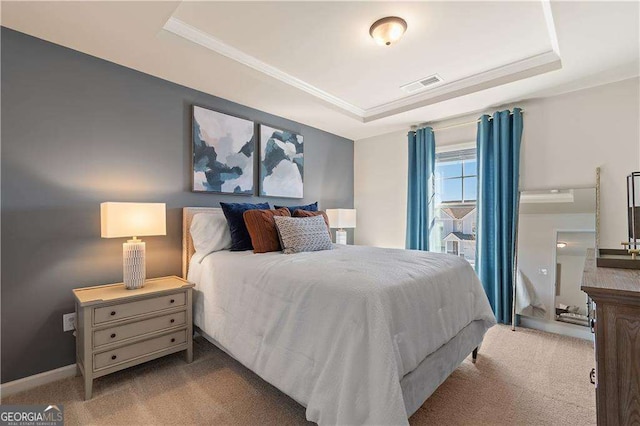 bedroom featuring baseboards, carpet flooring, a tray ceiling, and visible vents
