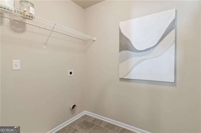 laundry area featuring dark tile patterned floors, baseboards, electric dryer hookup, and laundry area