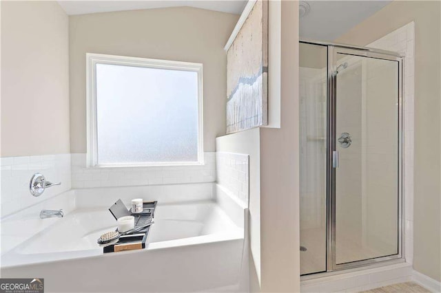 bathroom featuring a shower stall and a garden tub
