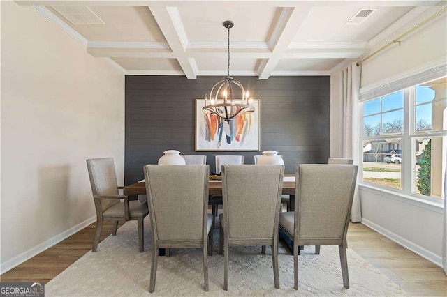 dining area featuring a chandelier, wood finished floors, visible vents, and baseboards