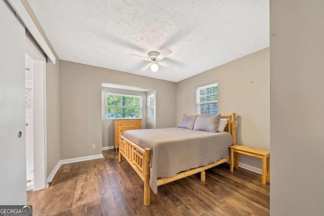 bedroom with baseboards, wood finished floors, a textured ceiling, and ceiling fan