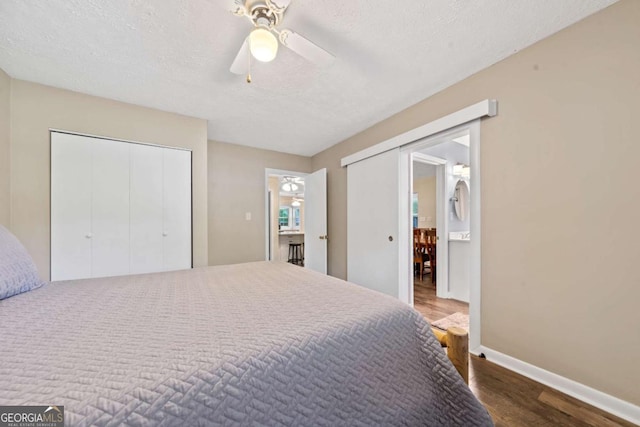 bedroom featuring baseboards, wood finished floors, a textured ceiling, and ceiling fan