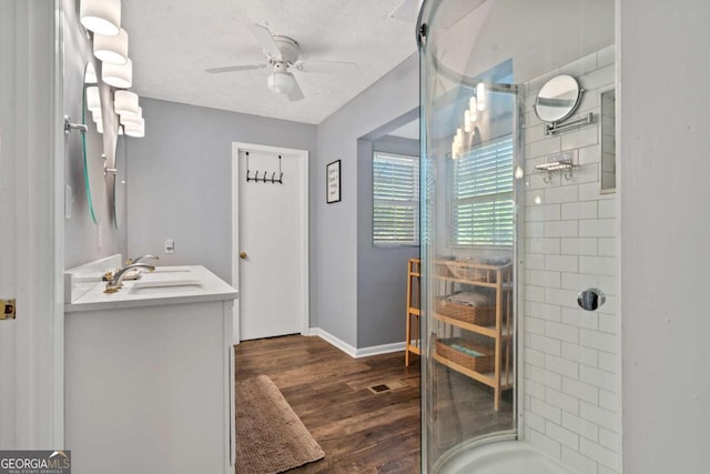 full bathroom with a shower stall, vanity, ceiling fan, and wood finished floors