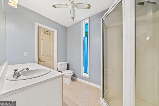 full bathroom with baseboards, toilet, vanity, and a stall shower