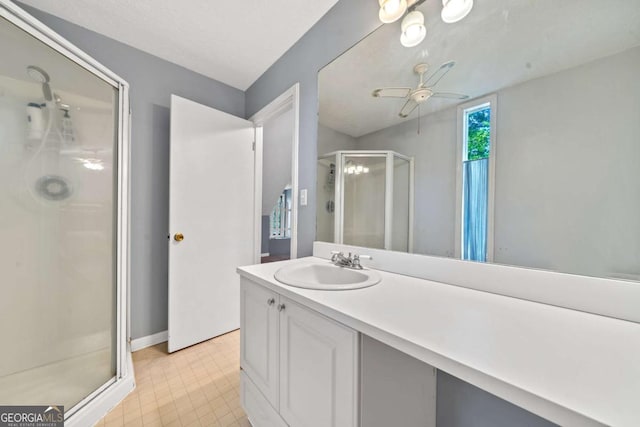 bathroom with a shower stall, tile patterned floors, vanity, ceiling fan, and baseboards