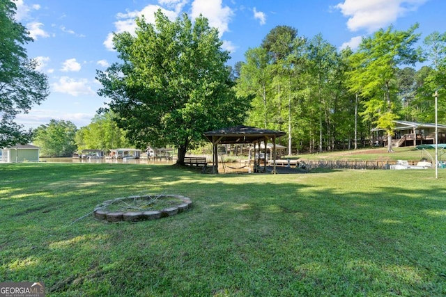 view of property's community with a lawn and an outdoor fire pit