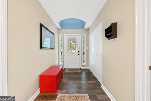 doorway featuring baseboards and wood finished floors