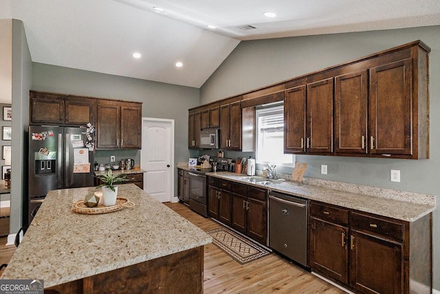kitchen with light wood-style flooring, dark brown cabinets, stainless steel appliances, and a sink