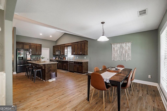dining room featuring recessed lighting, vaulted ceiling, visible vents, light wood-style floors, and baseboards