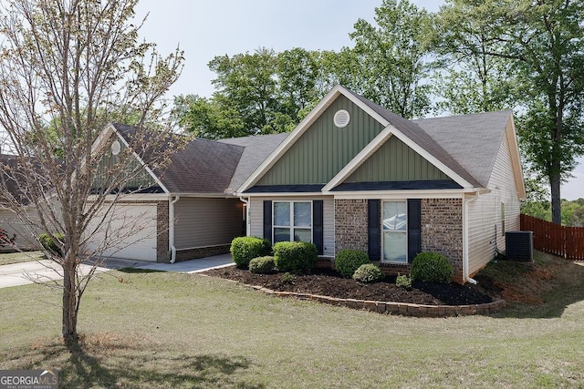 craftsman inspired home with central AC unit, fence, a front lawn, brick siding, and a garage