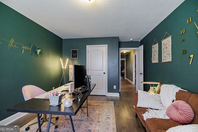 office space featuring baseboards, wood finished floors, and a textured ceiling