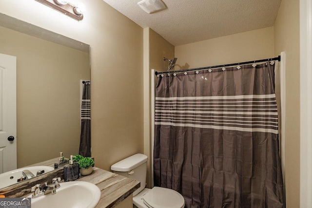 bathroom with visible vents, toilet, vanity, a shower with shower curtain, and a textured ceiling