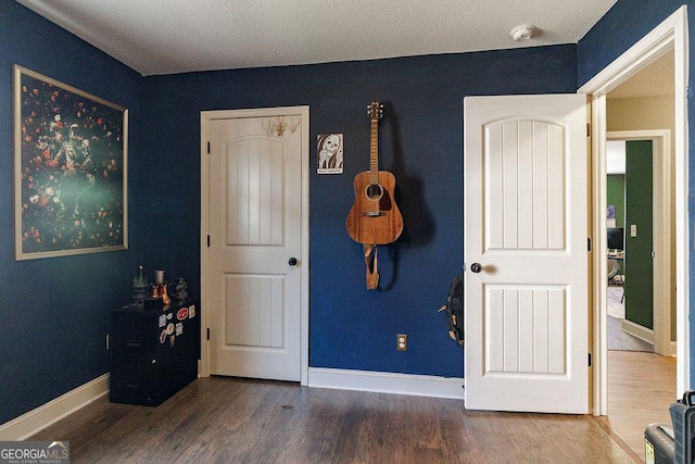 bedroom featuring baseboards and wood finished floors