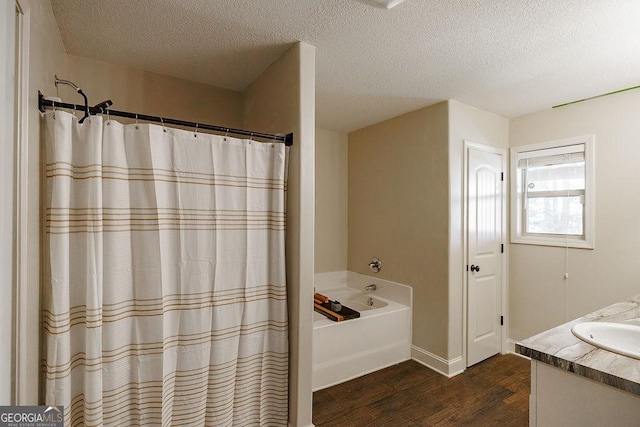 bathroom featuring a garden tub, wood finished floors, a textured ceiling, vanity, and a shower with shower curtain