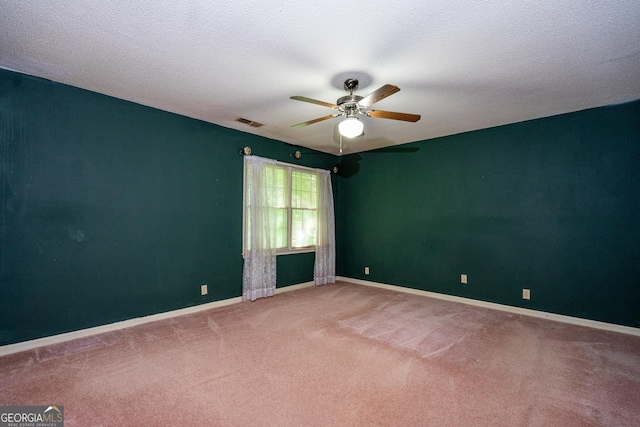 unfurnished room with a ceiling fan, a textured ceiling, baseboards, carpet flooring, and visible vents