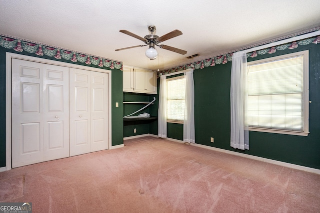 unfurnished bedroom featuring baseboards, a closet, and light colored carpet