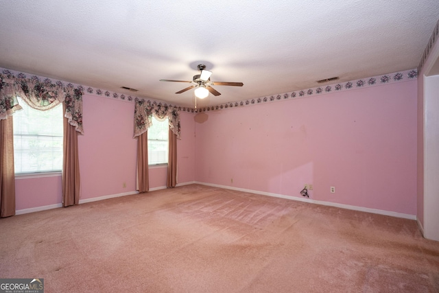 empty room featuring light carpet, baseboards, visible vents, and ceiling fan