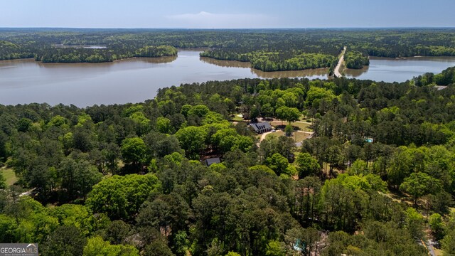 aerial view featuring a wooded view and a water view