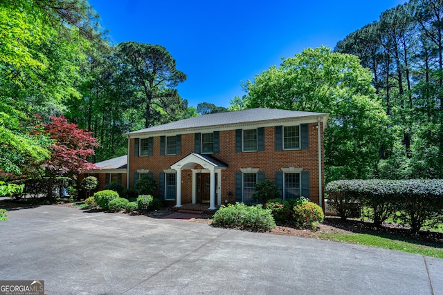 colonial home featuring brick siding