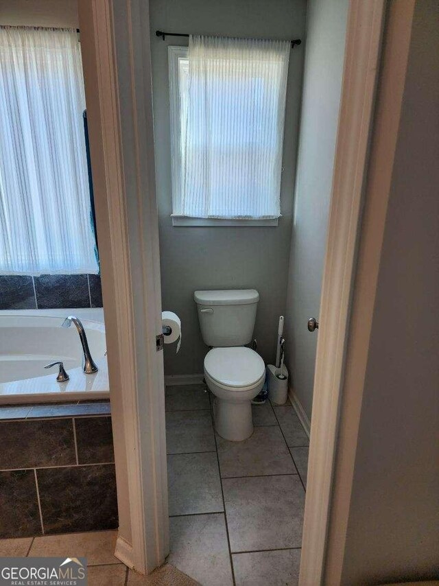 134 Sierra Cir, Woodstock, GA 30188 - bathroom featuring toilet, tile patterned flooring, a garden tub, and baseboards