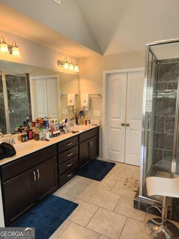134 Sierra Cir, Woodstock, GA 30188 - bathroom with a shower stall, tile patterned flooring, double vanity, vaulted ceiling, and a sink