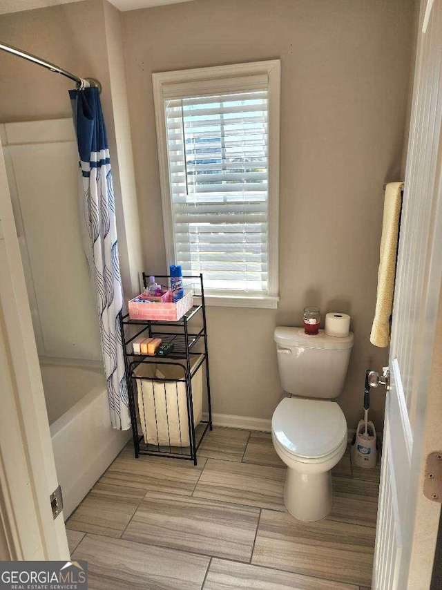 134 Sierra Cir, Woodstock, GA 30188 - bathroom with shower / tub combo, toilet, and baseboards