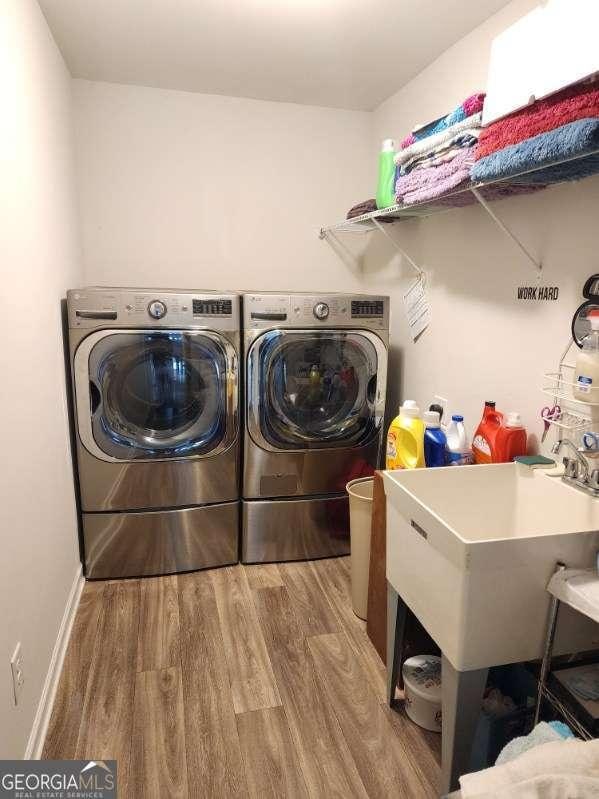 134 Sierra Cir, Woodstock, GA 30188 - laundry room featuring wood finished floors, laundry area, a sink, and separate washer and dryer