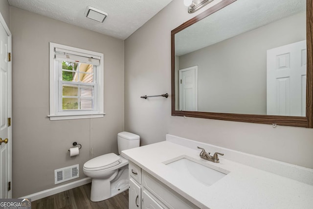 1320 Pinyon Pl, Lawrenceville, GA 30043 - half bathroom with toilet, wood finished floors, visible vents, baseboards, and vanity