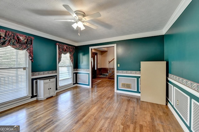 5800 S Richland Creek Rd, Buford, GA 30518 - unfurnished living room with a ceiling fan, a wainscoted wall, a textured ceiling, and light wood-type flooring