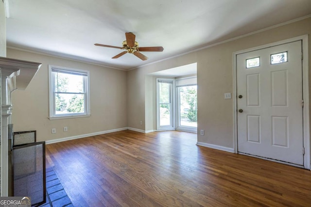 foyer featuring wood finished floors, a ceiling fan, ornamental molding, and baseboards