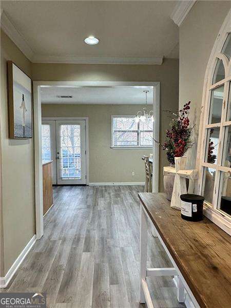 6630 Crystal Cove Trl, Gainesville, GA 30506 - interior space featuring crown molding, wood finished floors, an inviting chandelier, baseboards, and visible vents