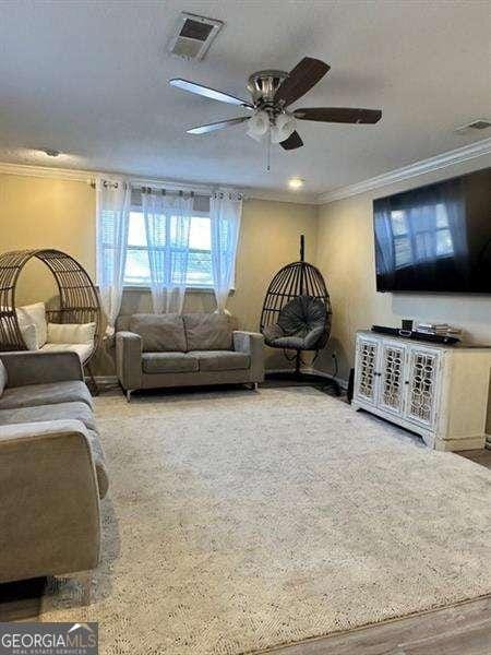 6630 Crystal Cove Trl, Gainesville, GA 30506 - living area featuring a ceiling fan, visible vents, and crown molding