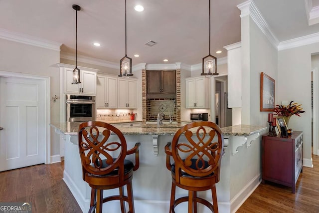 kitchen featuring light stone countertops, a breakfast bar area, backsplash, and appliances with stainless steel finishes