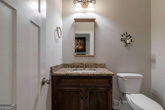 half bath featuring vanity and toilet