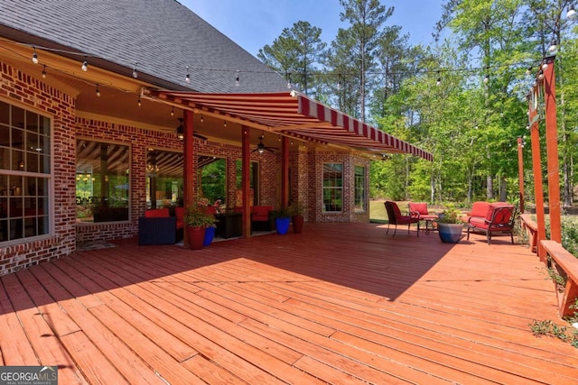 deck featuring outdoor lounge area and a ceiling fan