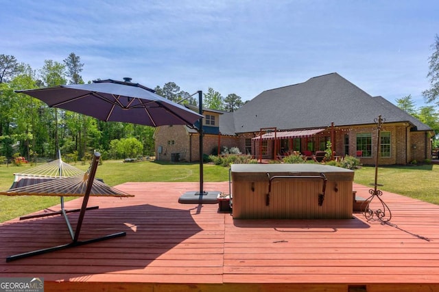 wooden deck featuring a lawn and a hot tub