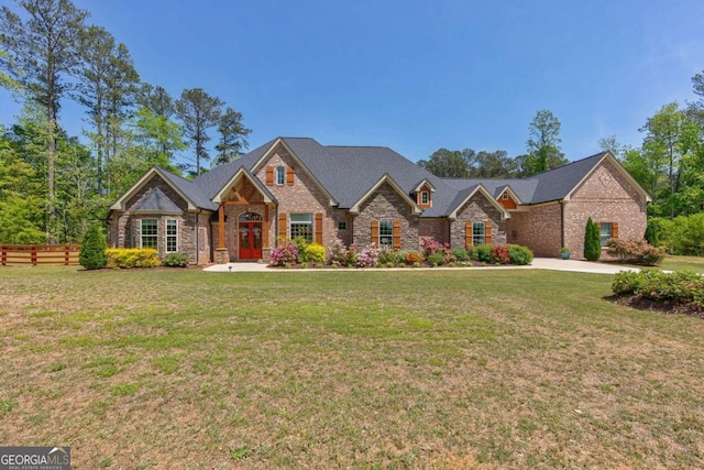 view of front of property with french doors, stone siding, a front yard, and fence