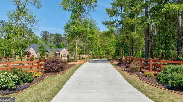view of home's community featuring fence and driveway