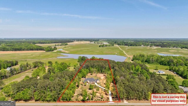 drone / aerial view with a water view and golf course view