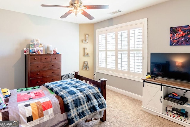 carpeted bedroom with baseboards, visible vents, and a ceiling fan