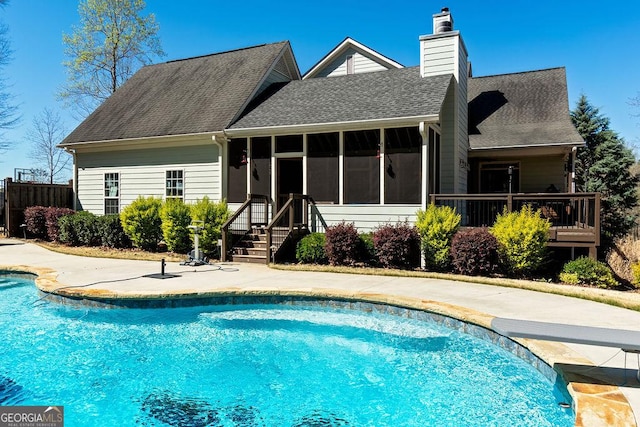 back of property with a fenced in pool, a chimney, roof with shingles, fence, and a sunroom