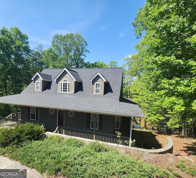 country-style home featuring a porch and a shingled roof