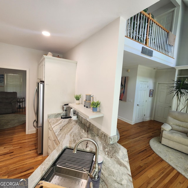 kitchen featuring white cabinets, freestanding refrigerator, light wood-style flooring, and open floor plan