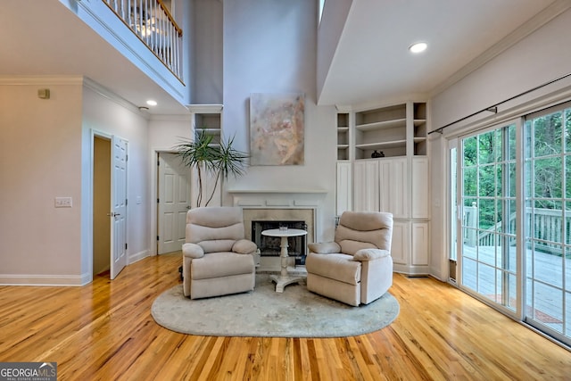 327 Kissimmee Trl, Cornelia, GA 30531 - living area featuring wood finished floors, ornamental molding, baseboards, built in shelves, and a high end fireplace