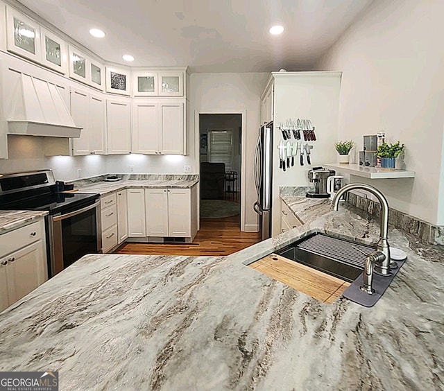 kitchen featuring recessed lighting, light stone countertops, appliances with stainless steel finishes, and a sink