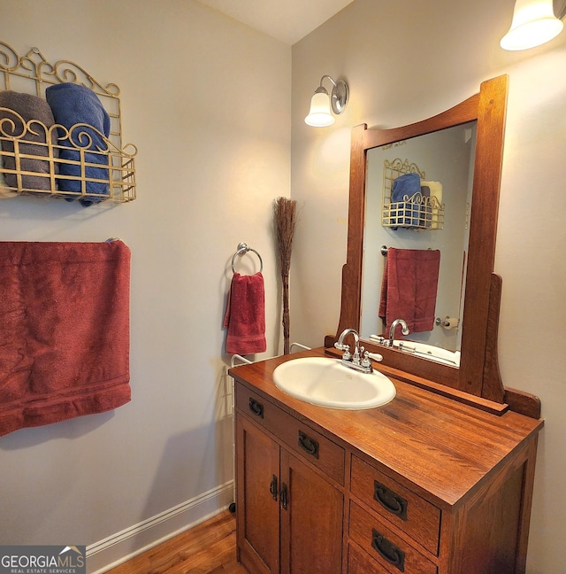 bathroom with baseboards, wood finished floors, and vanity