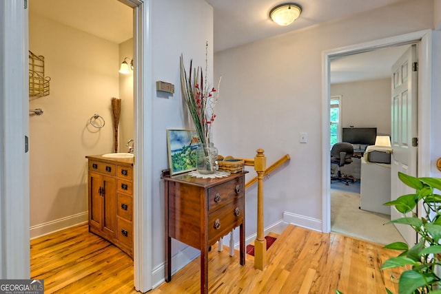 327 Kissimmee Trl, Cornelia, GA 30531 - corridor with a sink, light wood-style floors, an upstairs landing, a desk, and baseboards