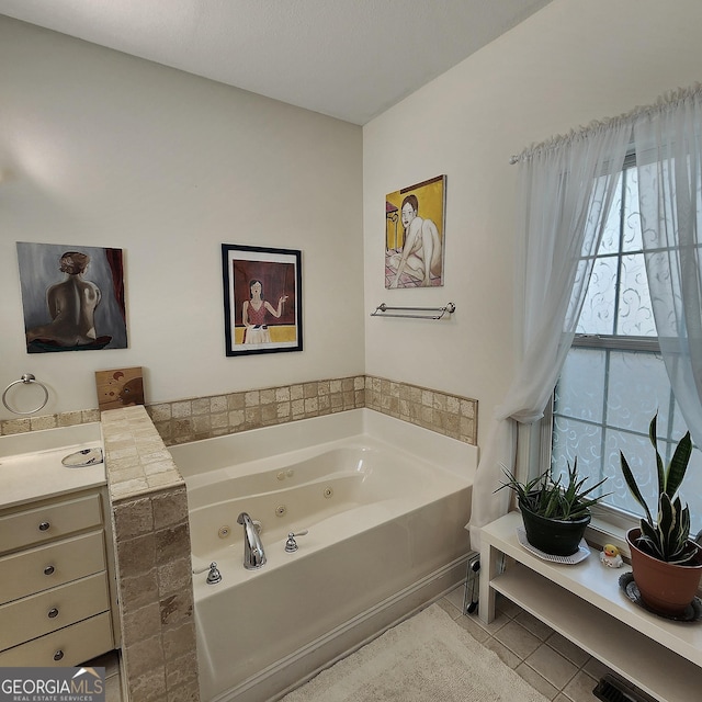 bathroom with a jetted tub, vanity, and tile patterned flooring