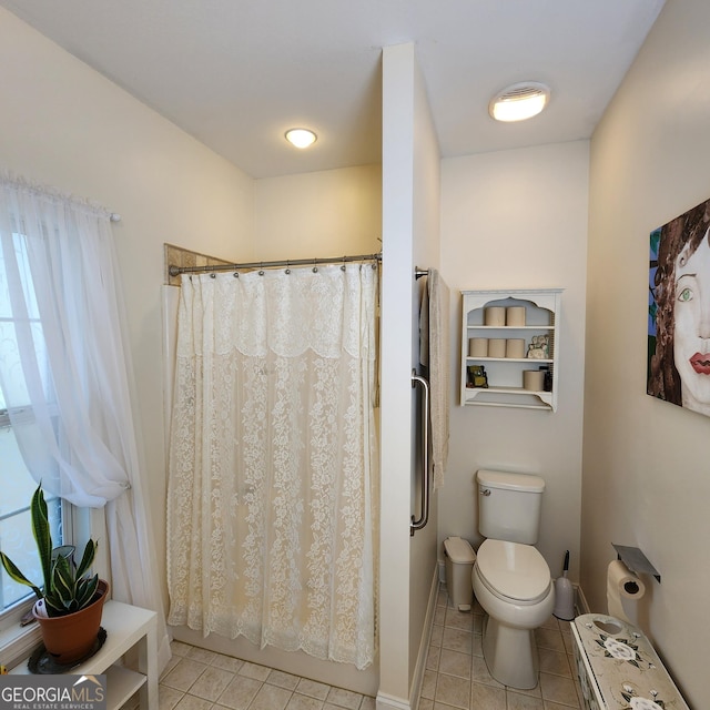 full bath with tile patterned flooring, curtained shower, a healthy amount of sunlight, and toilet